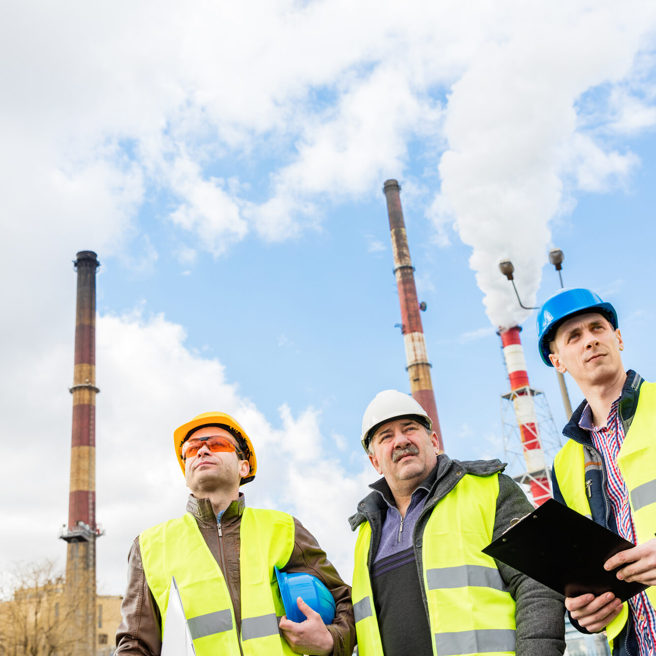 Construction engineers examining thermoelectric power station. Heat and electricity distribution industry. Teamwork.