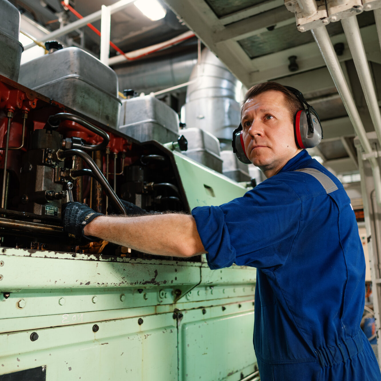 Marine engineer officer controlling vessel enginesand propulsion in engine control room ECR. Ship onboard maintenance